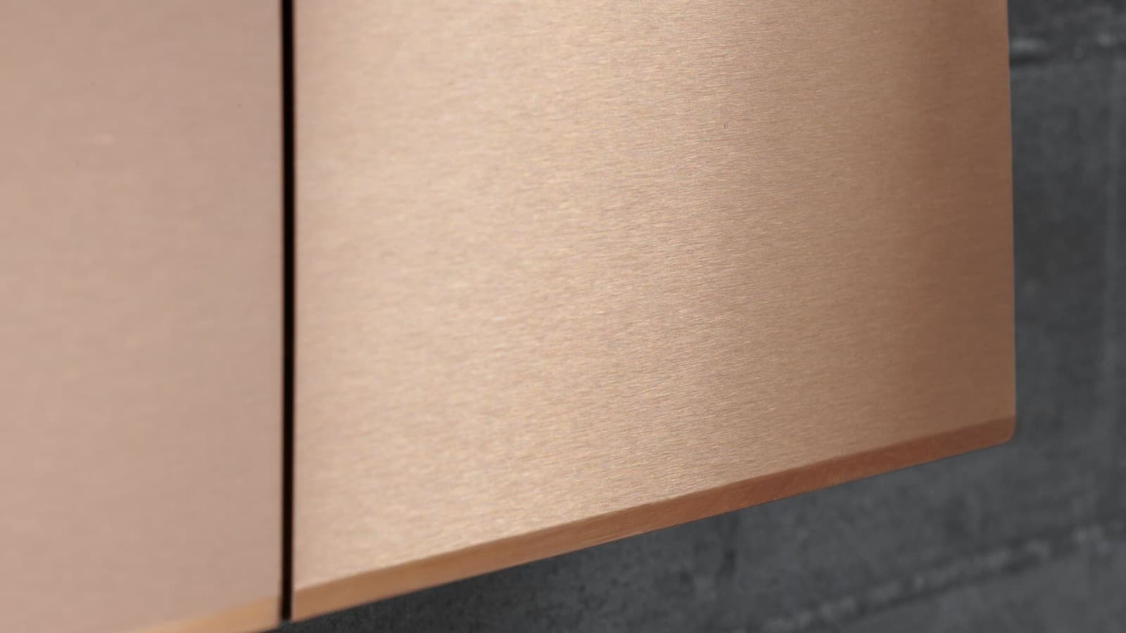 Closeup of Sigma70 flush plate in brushed red gold finish Closeup of Sigma70 flush plate in brushed red gold finish